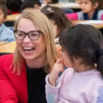 A happy JA female volunteer smiling at students.